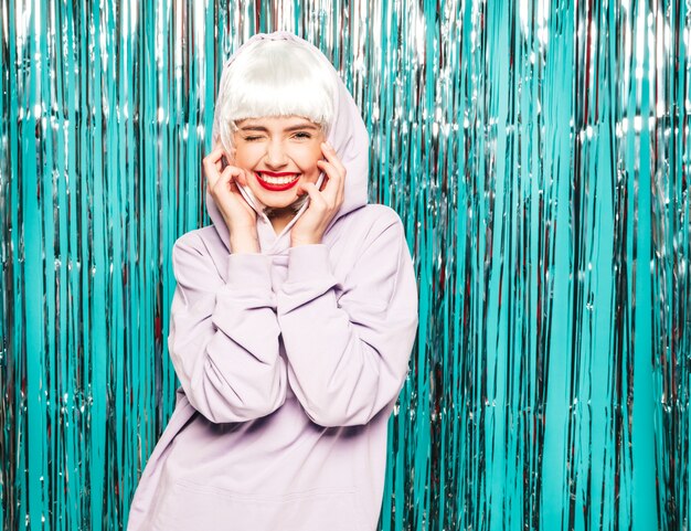 Young sexy smiling hipster girl in white wig and red lips.Beautiful trendy woman in summer clothes. going crazy