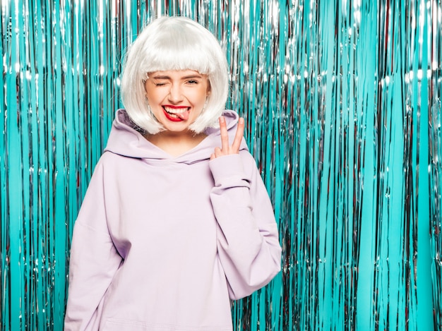 Young sexy smiling hipster girl in white wig and red lips.Beautiful trendy woman in summer clothes.