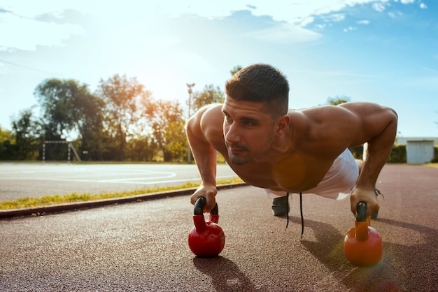 Young shirtless Caucasian male working out in the park at daytime