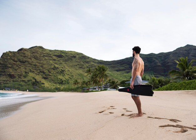 スキューバダイビング器材とビーチで若い上半身裸の男