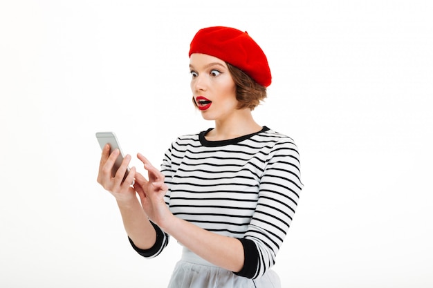 Young shocked woman chatting by mobile phone