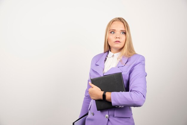 Young shocked woman holding tablet on white background. High quality photo