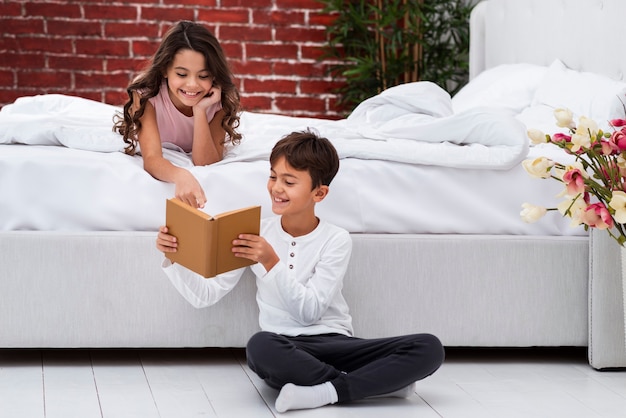 Free photo young siblings reading together stories