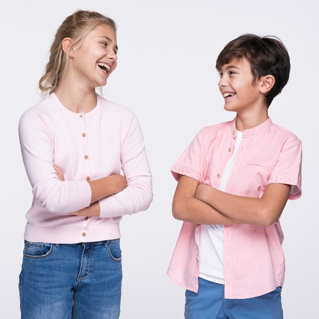 Free photo young siblings standing with arms crossed