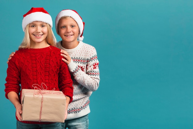 Young siblings with present copy space