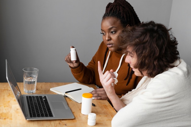 Young sick man and friend having a video call with a doctor