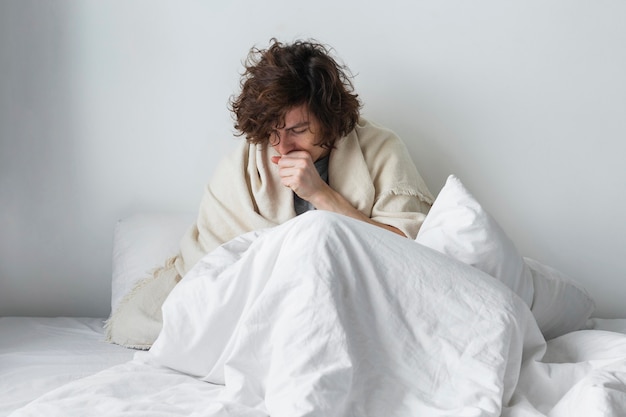 Free photo young sick man staying in his bed