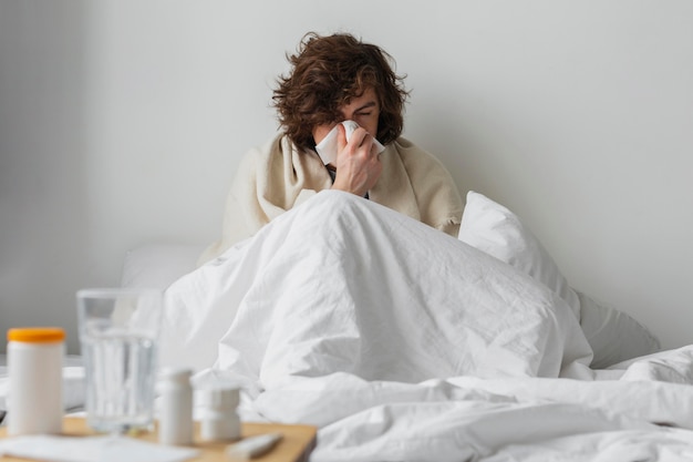 Бесплатное фото Молодой больной человек, оставаясь в своей постели