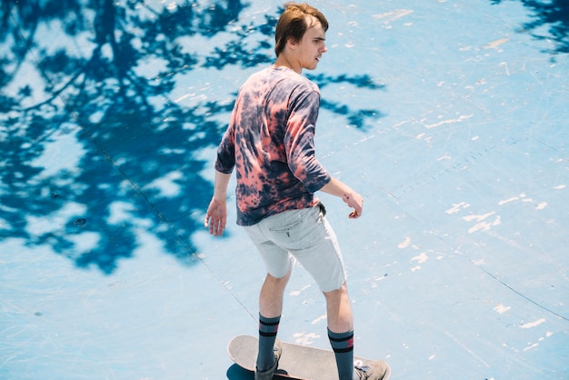Young skateboarder on ramp in sunny day
