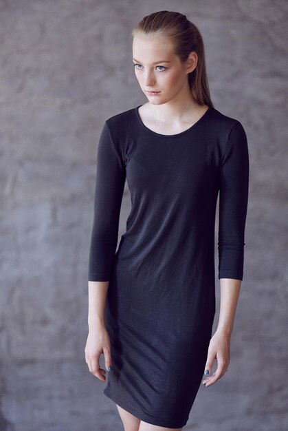 Young slim female in a black classic dress.