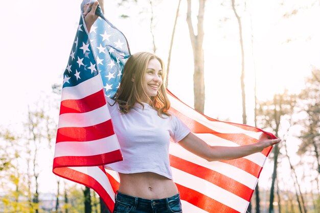 Young slim female holding USA flag on Independence Day