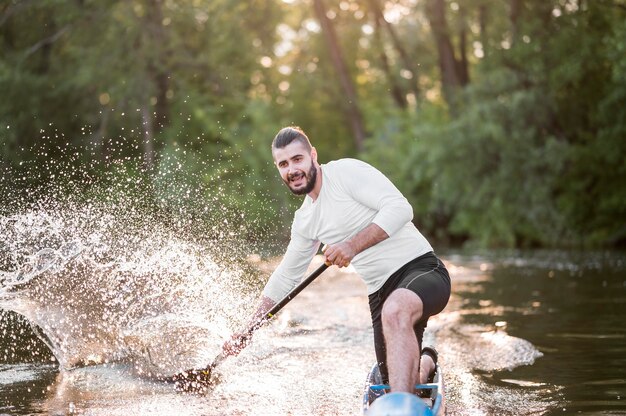 Young smiley man rowing