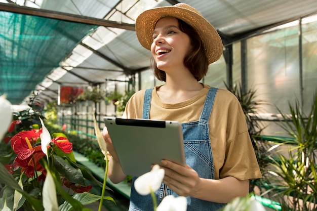 Young smiley woman working in a greenhouse