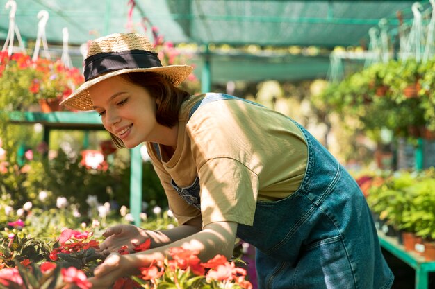 Young smiley woman working in a greenhouse