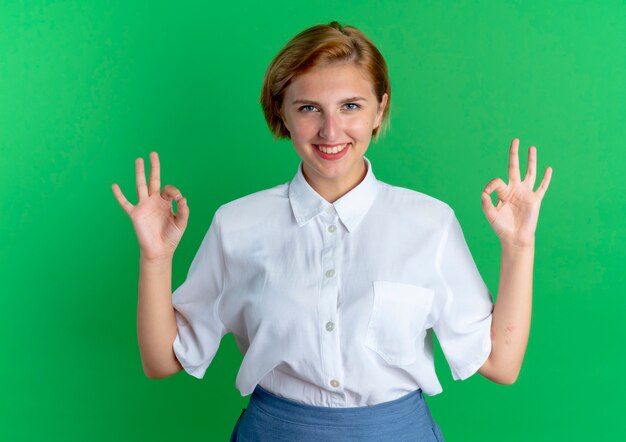 young smiling blonde russian girl gestures ok hand sign with two hands