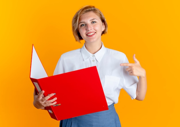 young smiling blonde russian girl holds and points at file folder