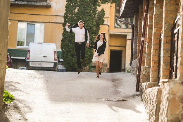 Young smiling couple jumping on the street