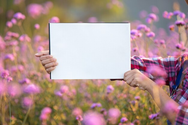 若い笑顔の農家は空の白い紙を立っていた。