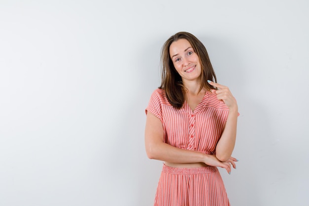 Young smiling girl shows to the left on a white background