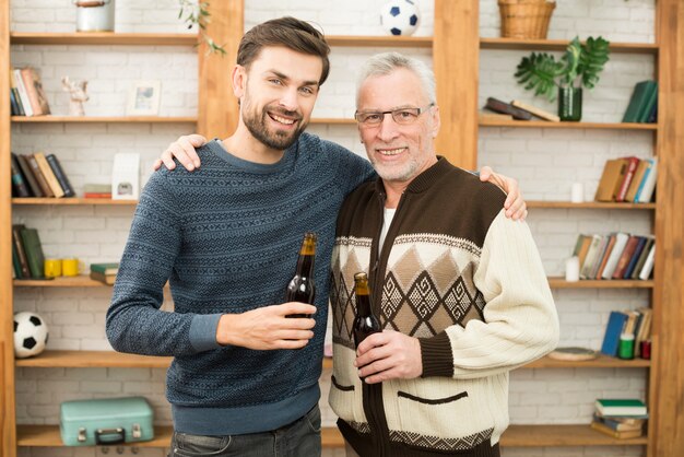 ボトルと高齢者の幸せな男と抱いて笑顔の若い男