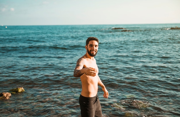 水の近くの若い微笑の男