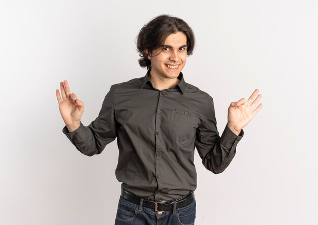 Young smiling handsome caucasian man gestures ok hand sign isolated on white background with copy space