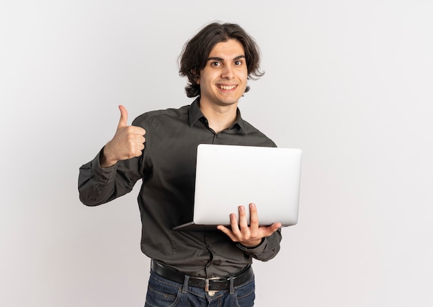 Young smiling handsome caucasian man holds laptop and thumbs up isolated on white background with copy space