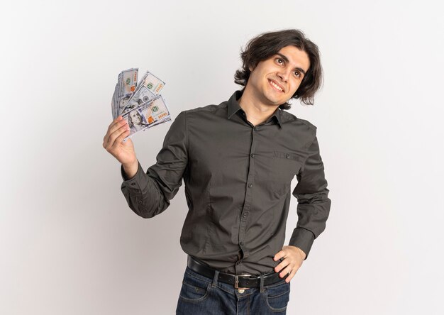 Young smiling handsome caucasian man holds money and looks at side isolated on white background with copy space