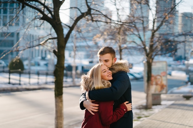 Young smiling happy european couple hugging in winter