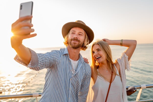 Young smiling happy man and woman traveling on bicycles taking selfie photo on phone camera