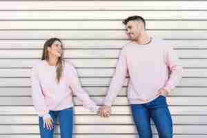 Free photo young smiling lady holding hands with happy handsome guy