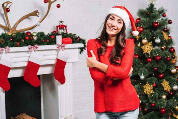 Young smiling lady near Christmas tree