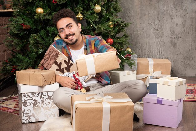 Free photo young smiling man choosing his present .