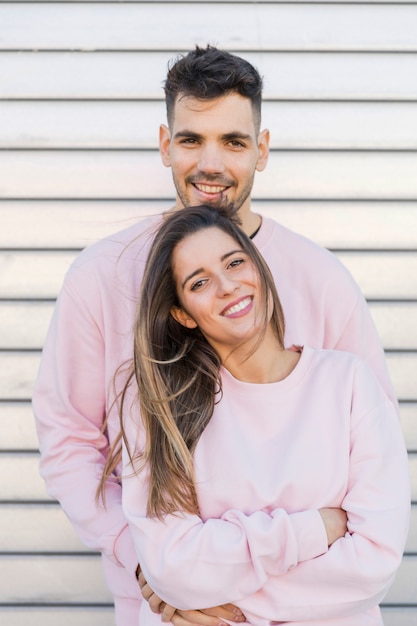 Young smiling man hugging attractive happy woman