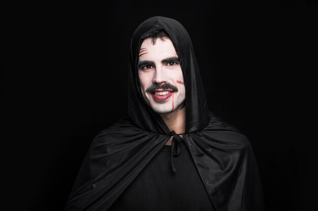 Young smiling man posing in black Halloween costume