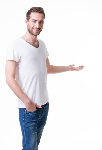 Young smiling man shows  something on arm -  isolated on white.