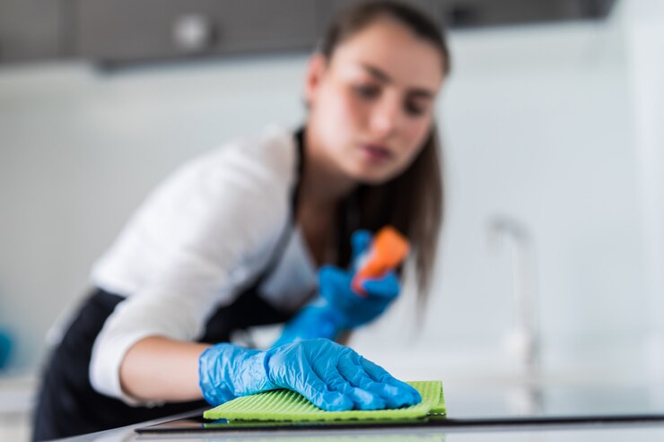 Free Photo young smiling woman cleans the kitchen at her home