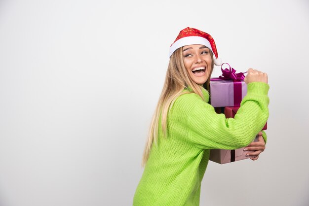 お祝いのクリスマスプレゼントを手に持って若い笑顔の女性。