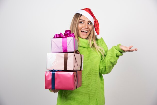 Young smiling woman holding in hands festive Christmas presents.