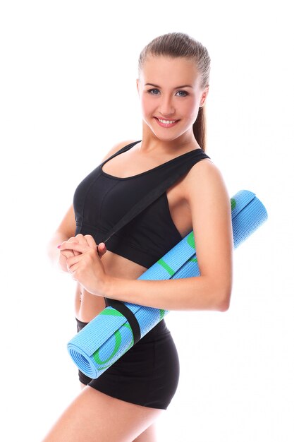 Young smiling woman holding mat for fitness