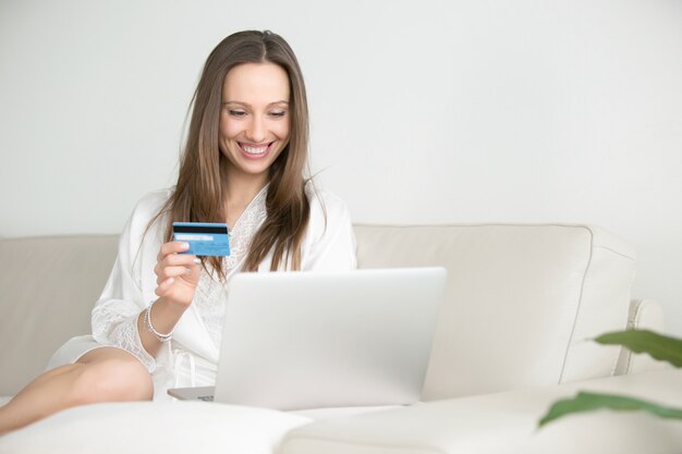 Young smiling woman paying with a card