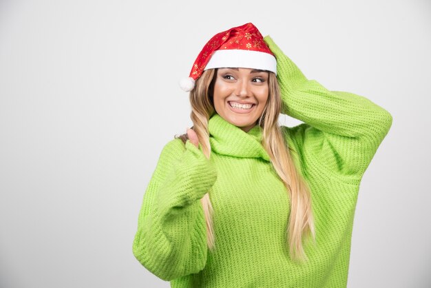 산타 클로스 빨간 모자에 포즈 젊은 웃는 여자.