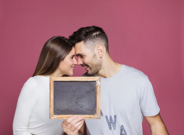 若い笑顔の女性とフォトフレームを示す正男