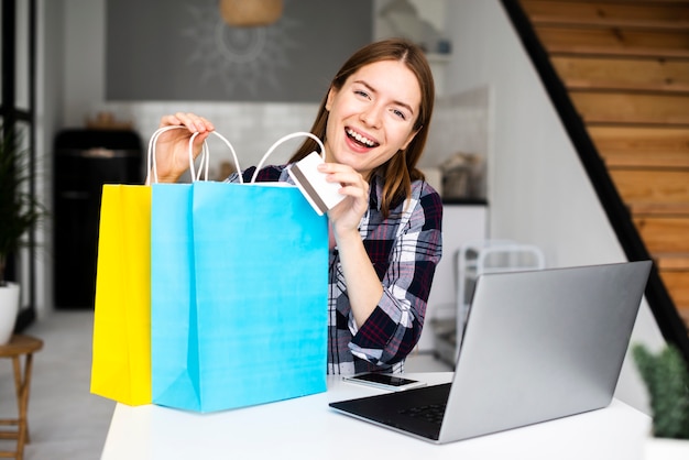 Young smiling woman showing shopping bags