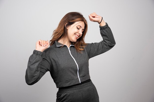 Young smiling woman standing and dancing.