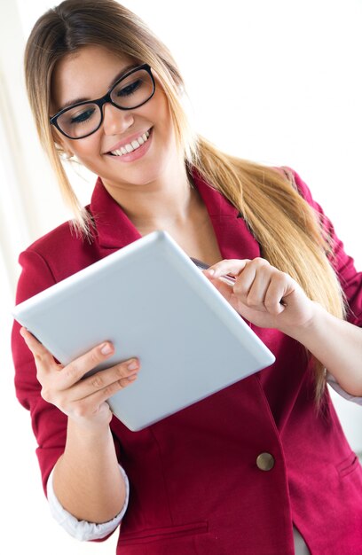 Young smiling woman using digital tablet. Isolated on white.