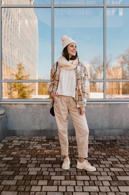 冬に通りを歩く若い笑顔の女性