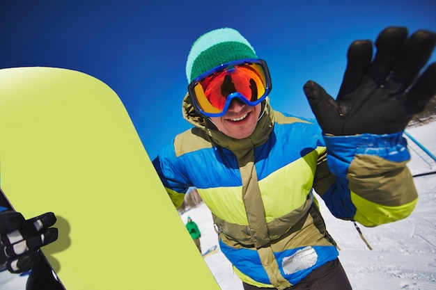 Young snowboarder holding his snowboard