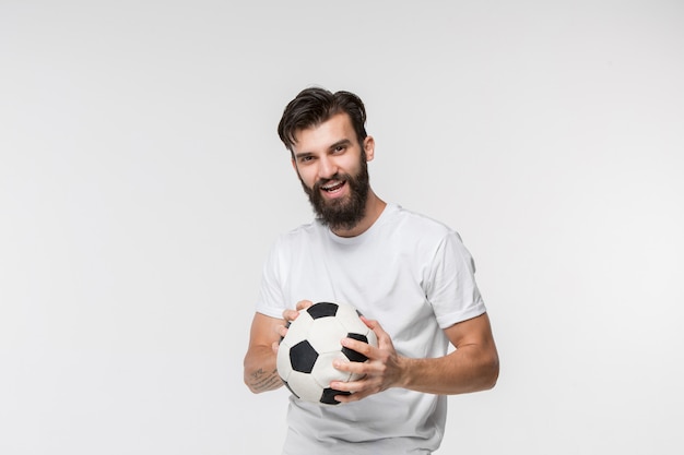 Free photo young soccer player with ball in front of white wall