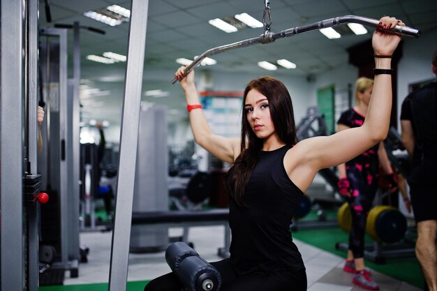 エクササイズをしているジムフィットネス女性の若いスポーツの女の子のトレーニング